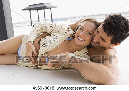 Stock Photo - Mid adult couple romancing at the poolside. Fotosearch