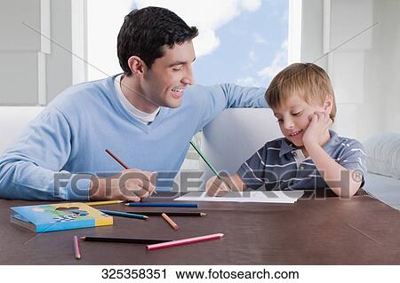 Mid adult man assisting his son in his homework View Large Photo Image Stock Image - Mid adult man assisting his son in his homework. Fotosearch