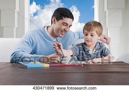 Mid adult man assisting his son in his homework View Large Photo Image Stock Photo - Mid adult man assisting his son in his homework. Fotosearch