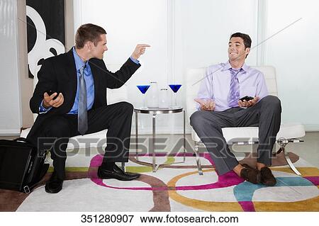 Mid adult man blaming a young man smiling View Large Photo Image Stock Photo - Mid adult man blaming a young man smiling. Fotosearch