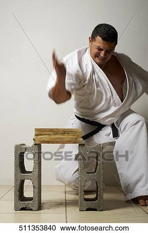 Mid adult man breaking a stack of woods with his hand View Large Photo Image Stock Image - Mid adult man breaking a stack of woods with his hand. Fotosearch