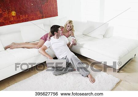 Mid adult man holding a credit card and using a laptop View Large Photo Image Stock Photograph - Mid adult man holding a credit card and using a laptop. Fotosearch