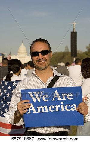 Mid adult man holding a signboard and smiling View Large Photo Image Stock Photo - Mid adult man holding a signboard and smiling. Fotosearch