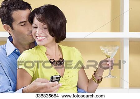 Mid adult man kissing a young woman smiling View Large Photo Image Picture - Mid adult man kissing a young woman smiling. Fotosearch