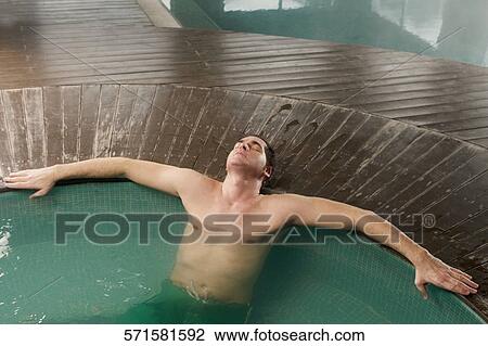 Mid adult man leaning at the poolside View Large Photo Image Stock Image - Mid adult man leaning at the poolside. Fotosearch
