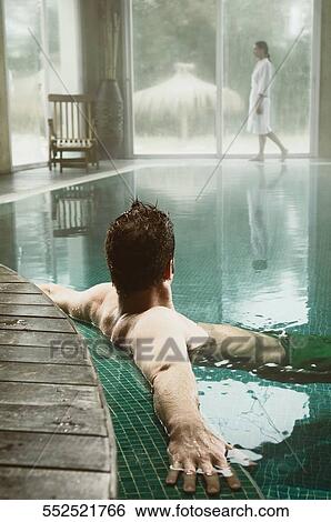 Mid adult man leaning at the poolside View Large Photo Image Stock Photograph - Mid adult man leaning at the poolside. Fotosearch