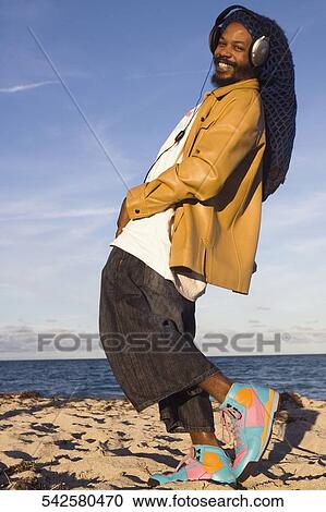Stock Image - Mid adult man listening to music and dancing. Fotosearch