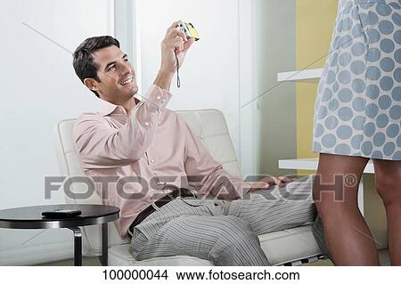 Picture - Mid adult man photographing of a woman with a digital camera. Fotosearch