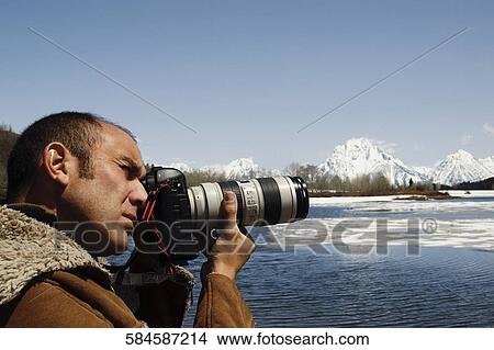 Mid adult man photographing with a camera, Grand Teton National Park, Wyoming, USA View Large Photo Image Picture - Mid adult man photographing with a camera, Grand Teton National Park, Wyoming, USA. Fotosearch