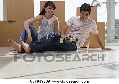 Mid adult man pouring champagne into champagne flute beside a mature woman View Large Photo Image Stock Photo - Mid adult man pouring champagne into champagne flute beside a mature woman. Fotosearch