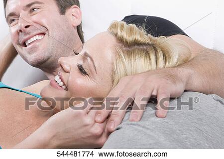 Mid adult man smiling with a young woman View Large Photo Image Picture - Mid adult man smiling with a young woman. Fotosearch