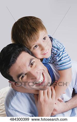 Mid adult man smiling with his son View Large Photo Image Stock Photo - Mid adult man smiling with his son. Fotosearch