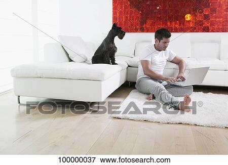 Mid adult man using a laptop View Large Photo Image Stock Photo - Mid adult man using a laptop. Fotosearch