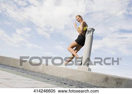 Mid adult woman leaning against a column and smiling View Large Photo Image Stock Photography - Mid adult woman leaning against a column and smiling. Fotosearch