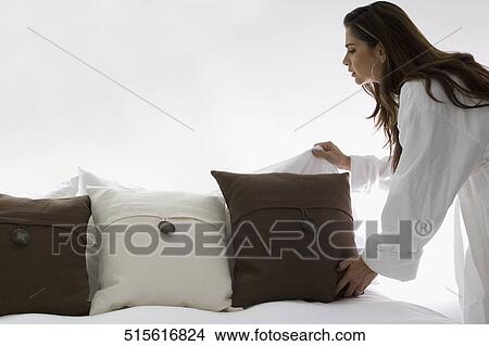 Mid adult woman making a bed View Large Photo Image Picture - Mid adult woman making a bed. Fotosearch