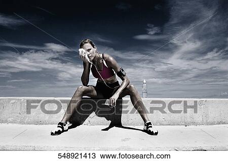 Mid adult woman sitting on a ledge View Large Photo Image Stock Image - Mid adult woman sitting on a ledge. Fotosearch