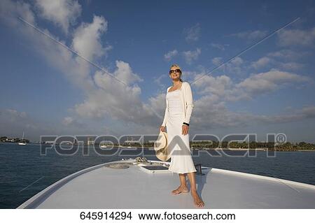 Mid adult woman standing on a ship's bow View Large Photo Image Picture - Mid adult woman standing on a ship's bow. Fotosearch