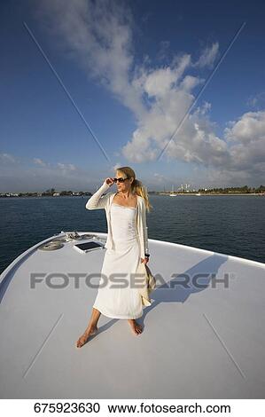 Mid adult woman standing on a ship's bow View Large Photo Image Stock Image - Mid adult woman standing on a ship's bow. Fotosearch