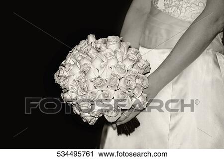 Mid section view of a bride holding a bouquet of white rose View Large Photo Image Stock Image - Mid section view of a bride holding a bouquet of white rose. Fotosearch