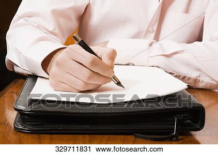 Mid section view of a businessman writing on a sheet of paper with a pen View Large Photo Image Stock Image - Mid section view of a businessman writing on a sheet of paper with a pen. Fotosearch