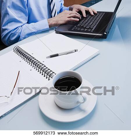 Mid section view of a businessman working on a laptop View Large Photo Image Stock Image - Mid section view of a businessman working on a laptop. Fotosearch