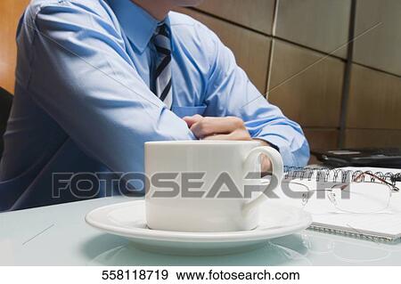 Mid section view of a businessman sitting in an office View Large Photo Image Stock Photo - Mid section view of a businessman sitting in an office. Fotosearch