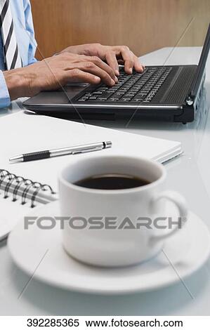 Mid section view of a businessman working on a laptop in an office View Large Photo Image Stock Photography - Mid section view of a businessman working on a laptop in an office. Fotosearch