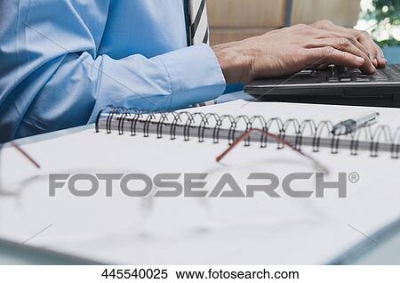Mid section view of a businessman working on a laptop View Large Photo Image Stock Photography - Mid section view of a businessman working on a laptop. Fotosearch