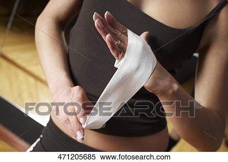 Mid section view of a female boxer wrapping her hand with a bandage View Large Photo Image Stock Photography - Mid section view of a female boxer wrapping her hand with a bandage. Fotosearch