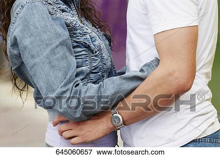Stock Photo - Mid section view of a man and a woman embracing each other. Fotosearch