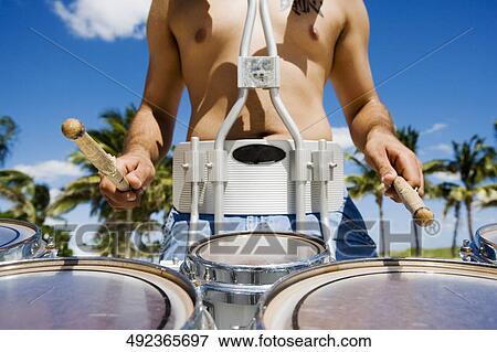 Mid section view of a man playing a drum View Large Photo Image Stock Photo - Mid section view of a man playing a drum. Fotosearch