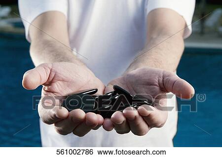 Mid section view of a man showing a hands cupped of pebbles View Large Photo Image Stock Photograph - Mid section view of a man showing a hands cupped of pebbles. Fotosearch
