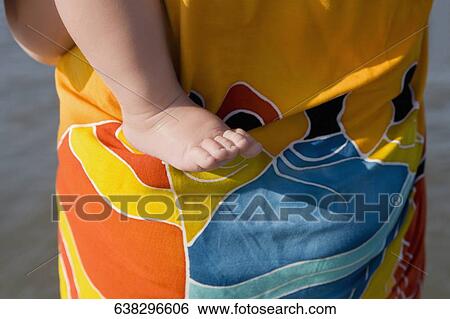 Mid section view of a person carrying her baby View Large Photo Image Stock Photograph - Mid section view of a person carrying her baby. Fotosearch