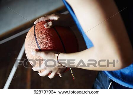 Mid section view of a person holding a basketball View Large Photo Image Picture - Mid section view of a person holding a basketball. Fotosearch