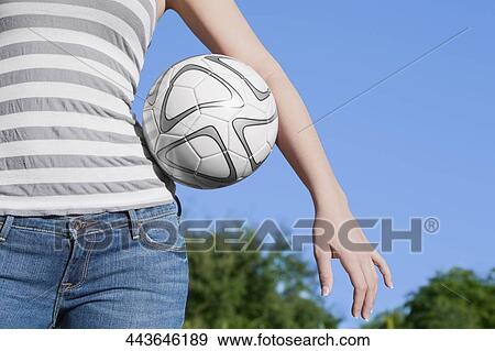 Mid section view of a teenage girl holding a soccer ball under her arm View Large Photo Image Stock Photo - Mid section view of a teenage girl holding a soccer ball under her arm. Fotosearch