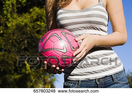 Mid section view of a teenage girl holding a soccer ball View Large Photo Image Stock Photo - Mid section view of a teenage girl holding a soccer ball. Fotosearch