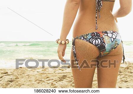 Mid section view of a woman standing on the beach View Large Photo Image Stock Image - Mid section view of a woman standing on the beach. Fotosearch