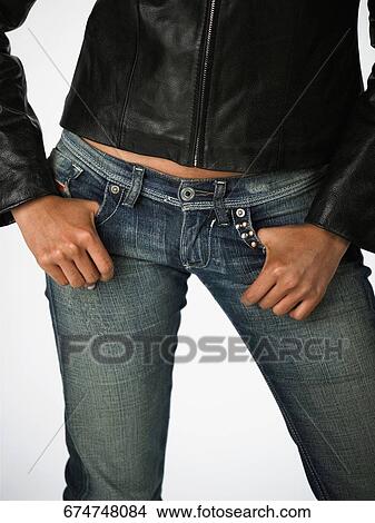 Mid section view of a woman with her hands in her pockets View Large Photo Image Picture - Mid section view of a woman with her hands in her pockets. Fotosearch