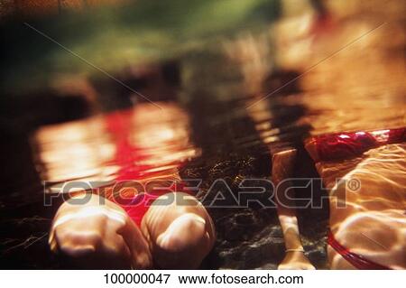 Mid section view of two women swimming underwater View Large Photo Image Stock Photo - Mid section view of two women swimming underwater. Fotosearch