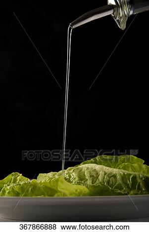 Olive oil being poured over cabbage leaves View Large Photo Image Stock Photo - Olive oil being poured over cabbage leaves. Fotosearch