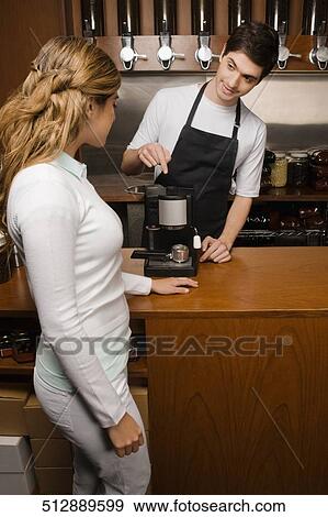 Owner showing a coffee maker to a customer View Large Photo Image Stock Photo - Owner showing a coffee maker to a customer. Fotosearch