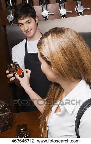 Owner showing coffee jar to a customer View Large Photo Image Stock Image - Owner showing coffee jar to a customer. Fotosearch