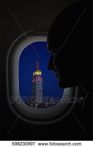 Stock Photo - Passenger looking at a building through the window of an airplane, Empire State Building, New York City, New York State, USA. Fotosearch