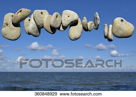 Pebbles in air with sea in the background View Large Photo Image Stock Photo - Pebbles in air with sea in the background. Fotosearch