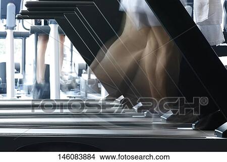 Person exercising on a treadmill machine in a gym View Large Photo Image Picture - Person exercising on a treadmill machine in a gym. Fotosearch