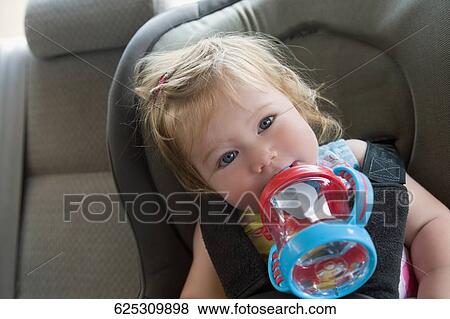 Portrait of a baby girl drinking water from a baby bottle View Large Photo Image Stock Photo - Portrait of a baby girl drinking water from a baby bottle. Fotosearch