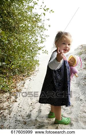 Portrait of a baby girl holding a doll and gesturing View Large Photo Image Stock Photo - Portrait of a baby girl holding a doll and gesturing. Fotosearch