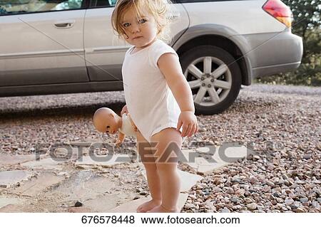 Portrait of a baby girl holding a doll View Large Photo Image Stock Photo - Portrait of a baby girl holding a doll. Fotosearch