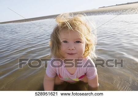 Portrait of a baby girl playing with water and smiling View Large Photo Image Stock Image - Portrait of a baby girl playing with water and smiling. Fotosearch