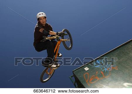 Portrait of a BMX cyclist performing in mid-air View Large Photo Image Stock Image - Portrait of a BMX cyclist performing in mid-air. Fotosearch